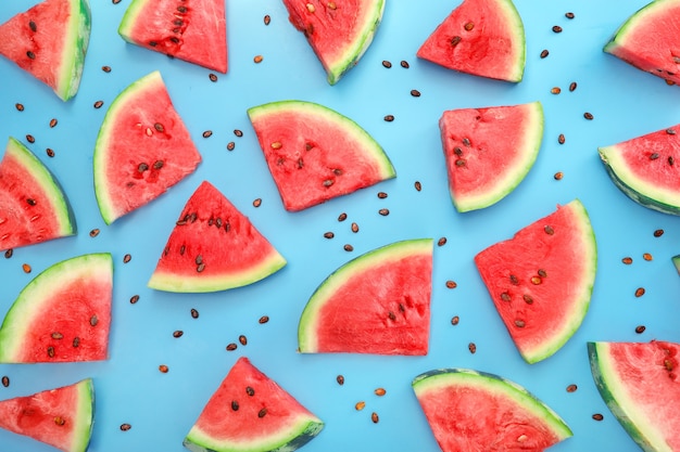 Ripe juicy watermelon pieces pattern on blue background. Top view.