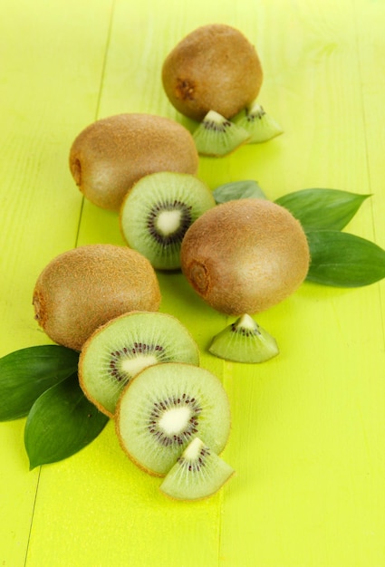 Ripe kiwi on green wooden table closeup