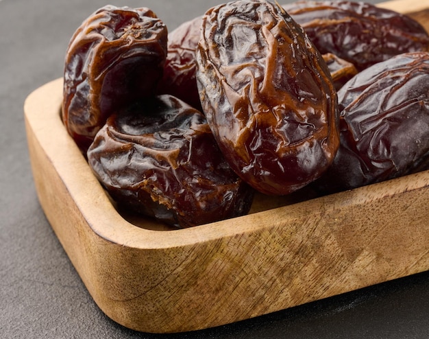 Ripe large dates in a wooden plate