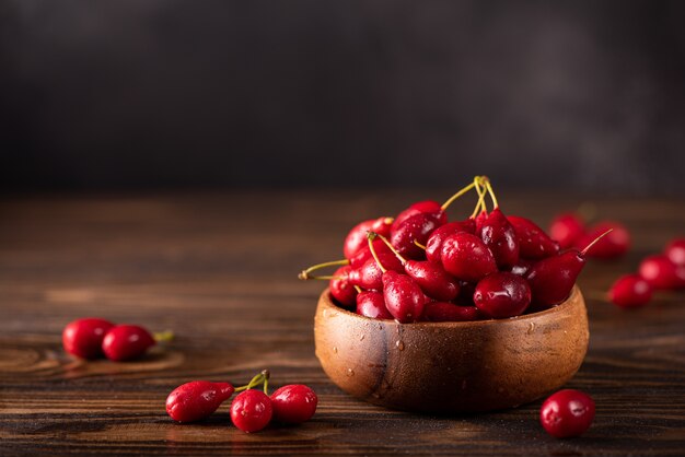 Ripe large dogwood berries in a wooden bowl