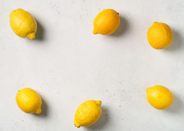 Ripe lemons frame on white table. top view