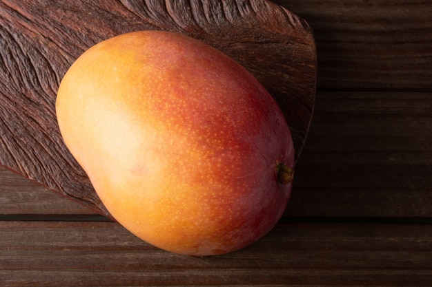 Ripe mango fruit isolated on wooden background.