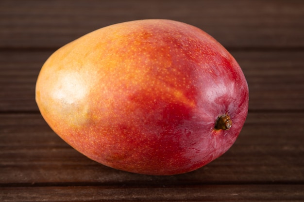 Ripe mango fruit isolated on wooden background.