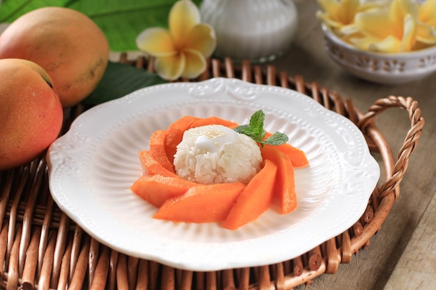 Ripe mango and sticky rice with coconut milk on rustic wood background, Thai dessert on summer season