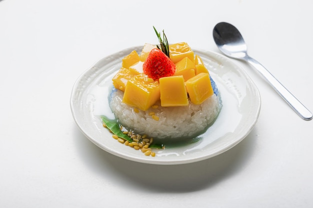 Ripe Mango with Coconut Flavored Sticky Rice on white dish Popular Thai desserts