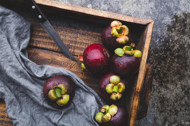 Photo ripe mangosteen fruits on a wooden crat