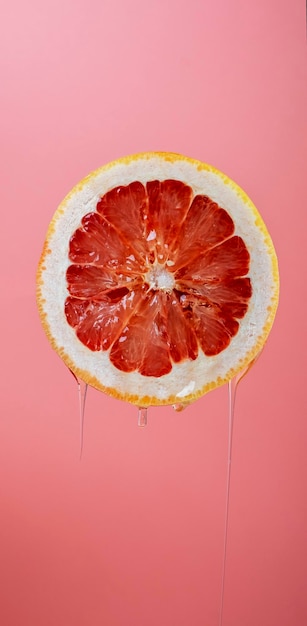 Ripe orange grapefruit cut in half and dripping with juice on a bright background Closeup