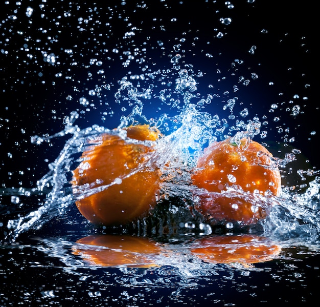 Ripe oranges with water splash