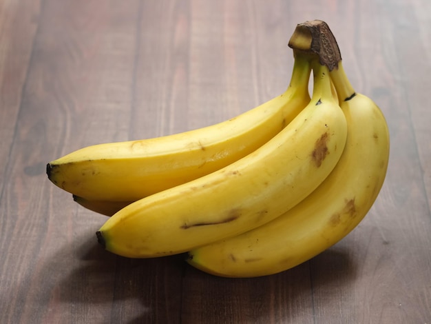 Ripe organic cavendish banana on wooden background with clipping path