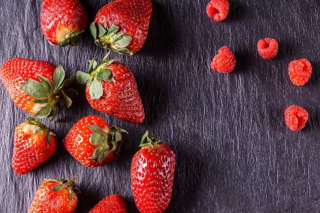 Ripe organic strawberries on black background