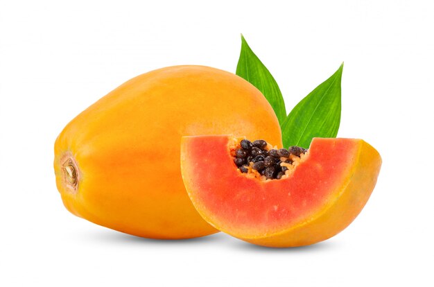 Ripe papaya fruit with leaves on white wall. 