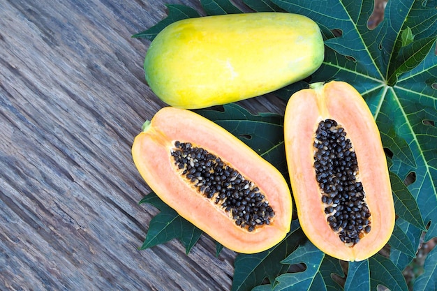 Ripe papaya with green leave on old wood table