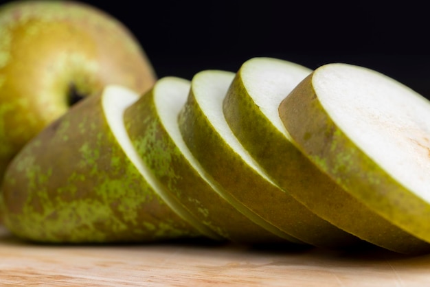 Ripe pear cut into different pieces green pear pieces on the table cooking dishes