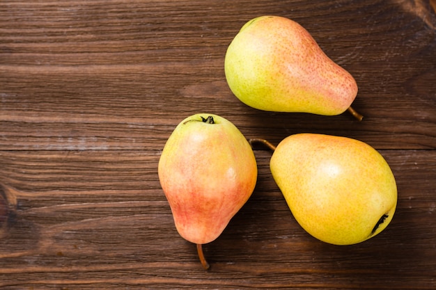 Ripe pears on a wooden table, top view