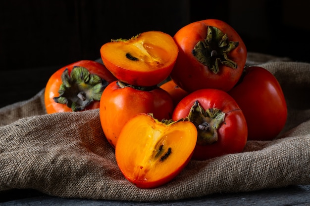 Ripe persimmon on wooden background. date-plum or sharon fruit. kaki persimmon fruit. Local food.