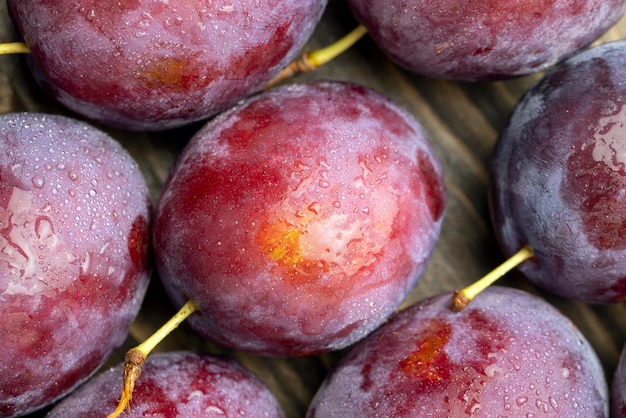 Ripe plums of dark color on the table, a harvest of ripe plums for cooking and desserts