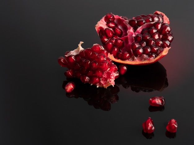 Ripe pomegranate on a dark surface