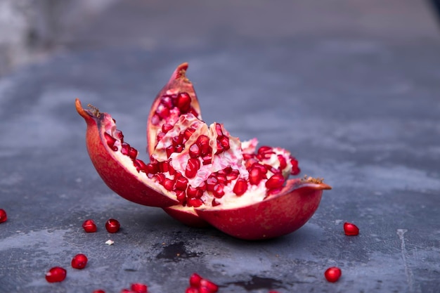 Ripe pomegranate fruit on a dark stone background