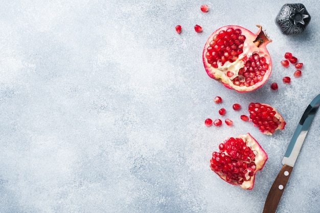 Ripe pomegranate fruit on a gray textured background.