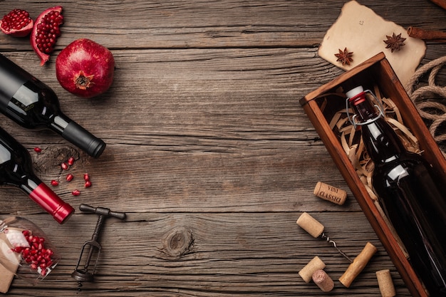 Ripe pomegranate fruit with a glass of wine, a bottle in a box on a wooden background