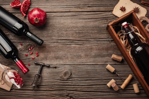 Ripe pomegranate fruit with a glass of wine, a bottle in a box on a wooden background