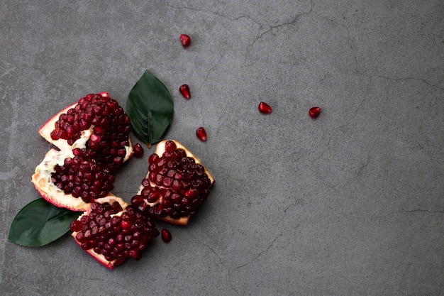 Ripe pomegranate fruits on a dark background, top view with copy space.