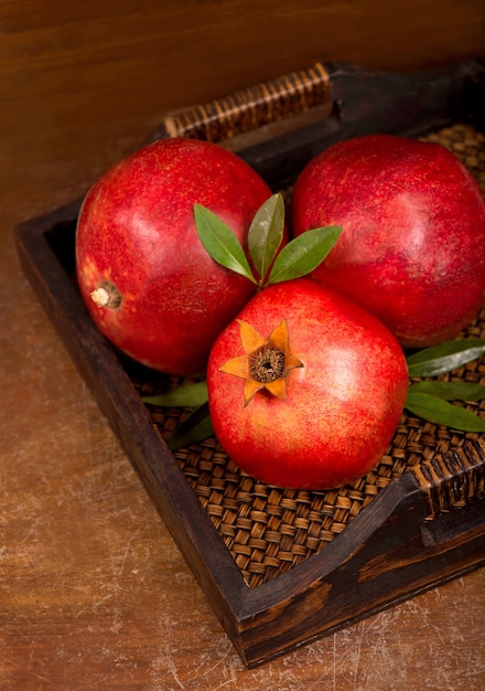 Ripe pomegranate fruits on the wooden background. Top view.