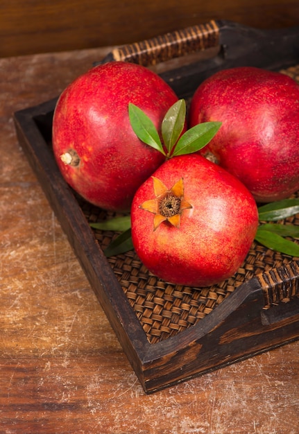 Ripe pomegranate fruits on the wooden background. Top view.