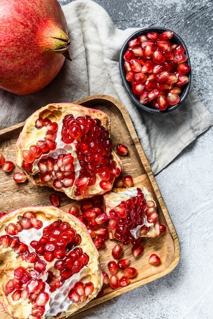 Ripe pomegranate and seeds in a wooden bowl. Organic fruit. 