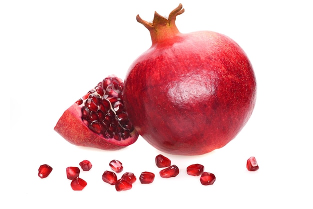 Ripe pomegranate whole fruit with slice and seeds isolated on a white background in closeup