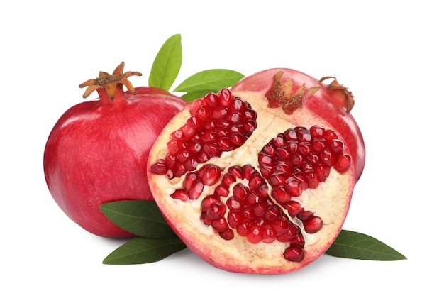 Ripe pomegranates with green leaves on white background