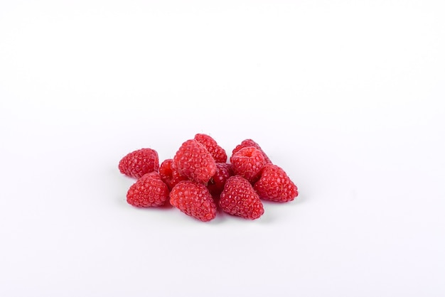 Ripe raspberries with raspberry leaves isolated on a white surface