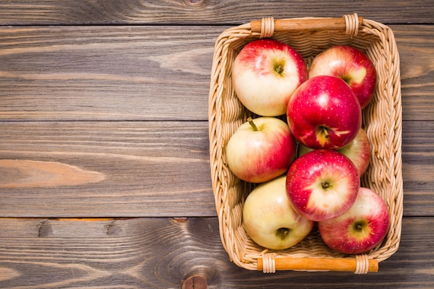 Ripe red apples in a basket on a wooden table. copyspace. copyspace