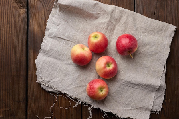 Ripe red apples on a gray linen napkin top view