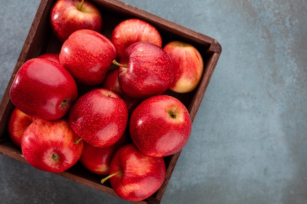 Ripe red apples in wooden box. Top view with space for your text.