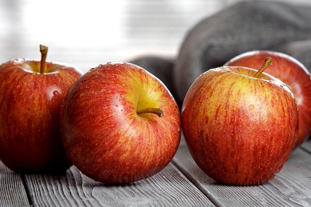 Ripe red apples on a wooden table closeup