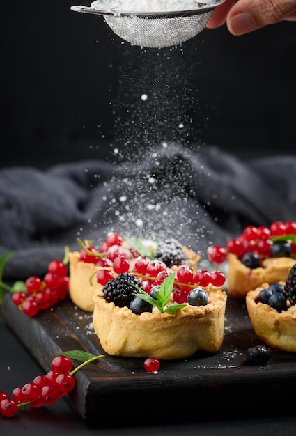 Ripe red cherries in a plate on a white table close up