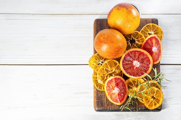 Ripe red oranges on wooden cut board. Sliced ripe juicy sicilian blood oranges on wooden background. Copy space.