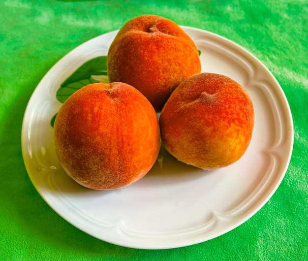 Ripe red peaches on a plate