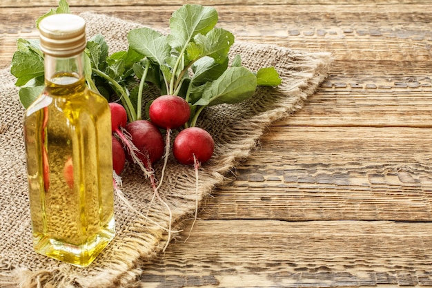 Ripe red radishes with green leaves on sackcloth and wooden boards