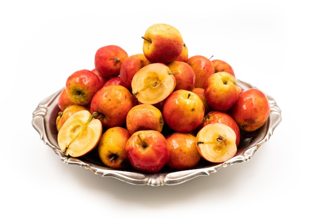 Ripe red small apples Ranetka on a metal plate on a white background Isolated background