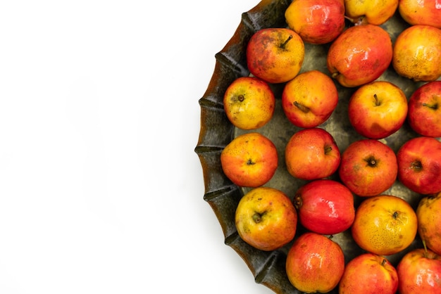 Ripe red small apples Ranetka on a metal plate on a white background Isolated background