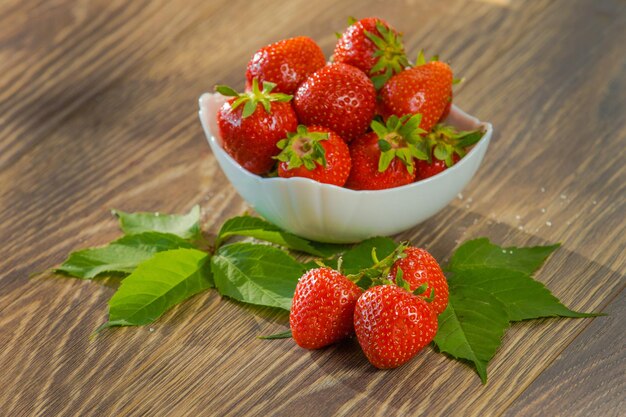 Ripe red strawberries Bowl filled with juicy fresh ripe red strawberries strawberries on a wooden table Fresh strawberries healthy food photo