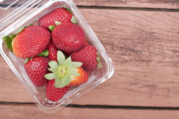 Ripe Red Strawberries in a plastic container on table