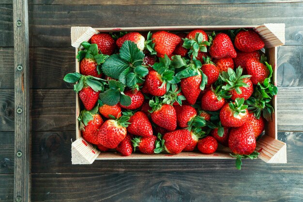 Ripe red strawberry in a wooden box Strawberry background top view