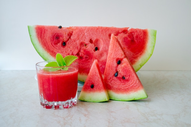 Ripe red watermelon slices and glass of smoothie