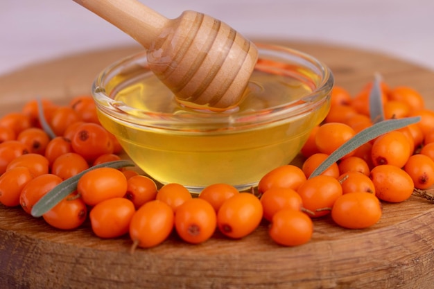 Ripe sea buckthorn berries with honey. Close-up. Healthy food.