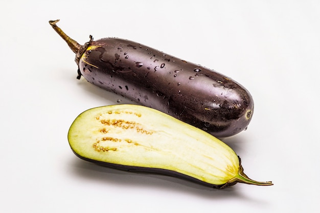 Ripe single eggplant. Fresh whole and half vegetable.