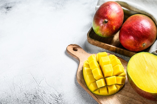 Ripe sliced mango fruit on a chopping Board. Gray background. Top view. Copy space