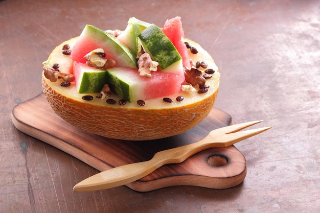 Ripe slices of watermelon and melon on a wooden board on a dark background Healthy and beautiful watermelon and melon closeup